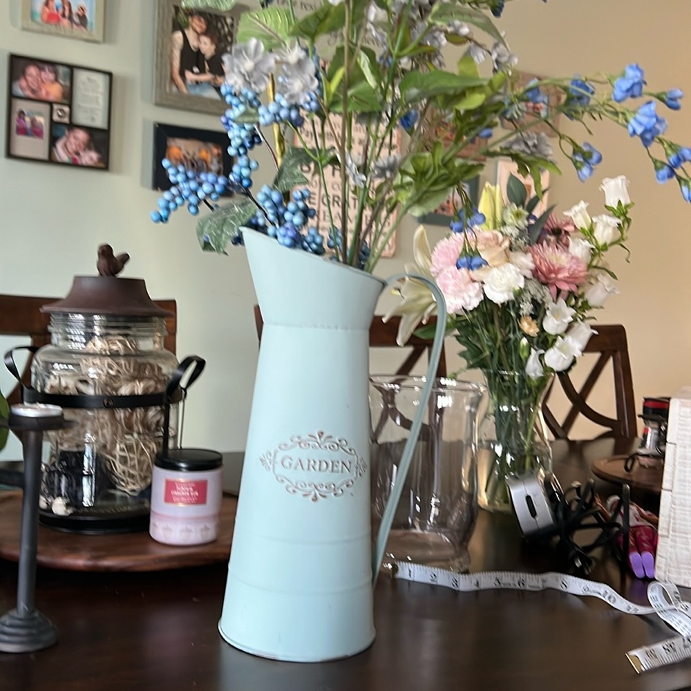 Metal vintage country watering can and home decor with flowers and berries